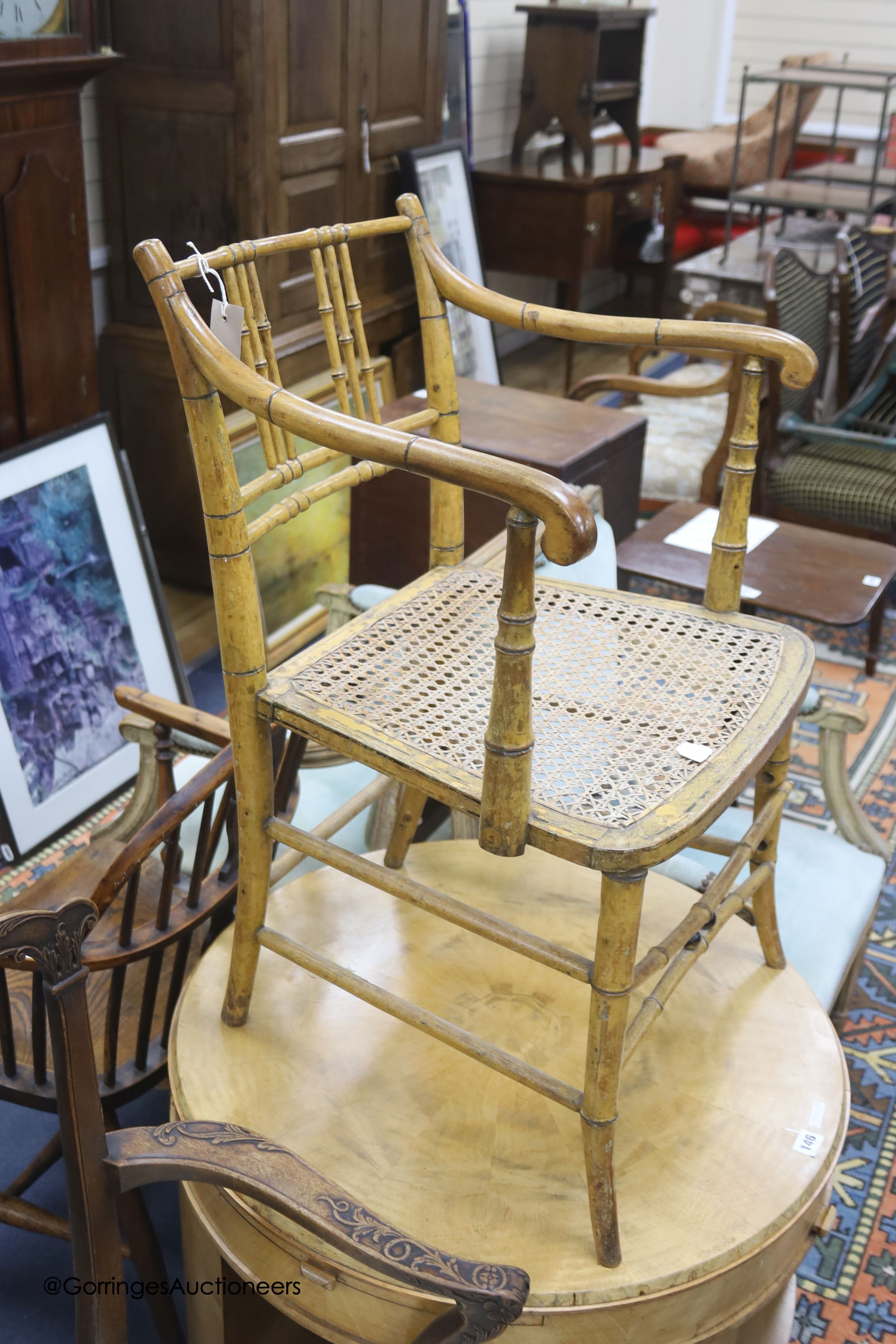 An early 19th century simulated bamboo elbow chair, cane seat
